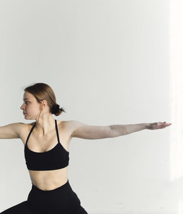 Woman in a graceful yoga pose in a calm studio.